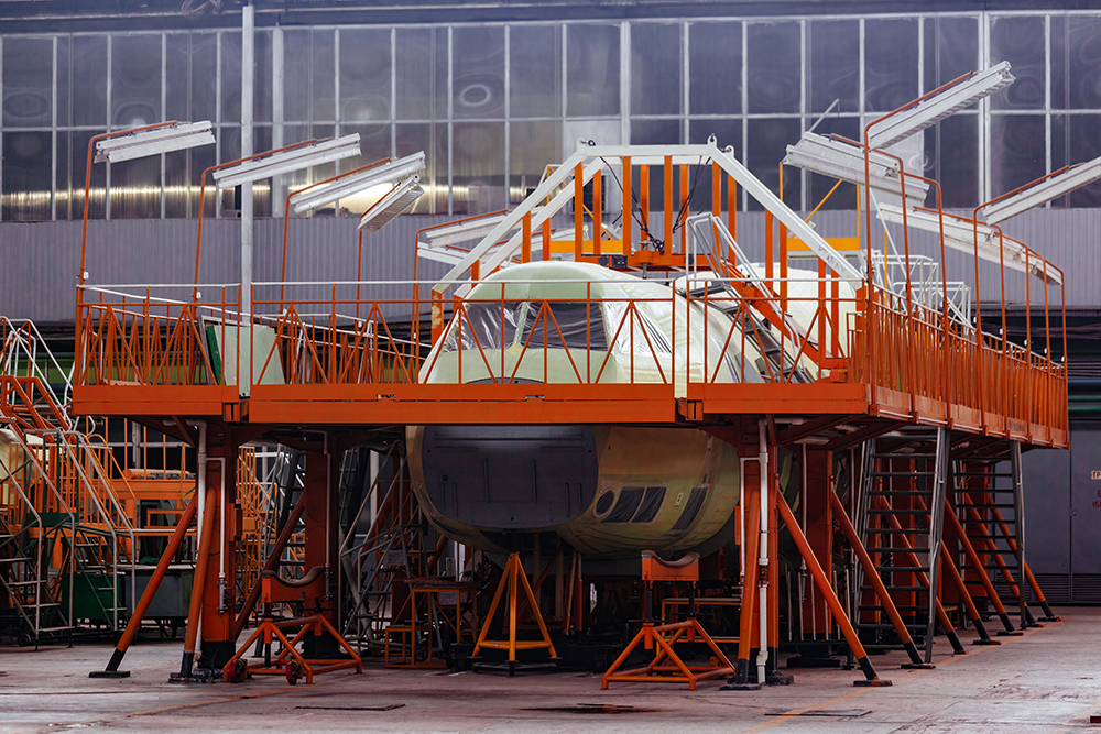 image of an aerospace facility with mezzanines and a jet being work on.